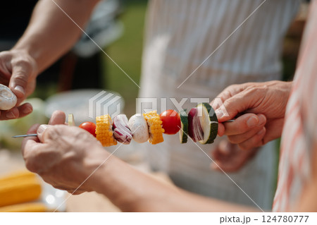 Close up of family preparing food for a spring weekend barbecue. Close up of family preparing food for a spring weekend barbecue. 124780777
