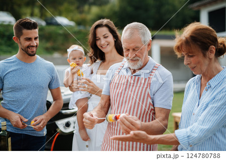 Three generations of family preparing food for a spring weekend barbecue. 124780788