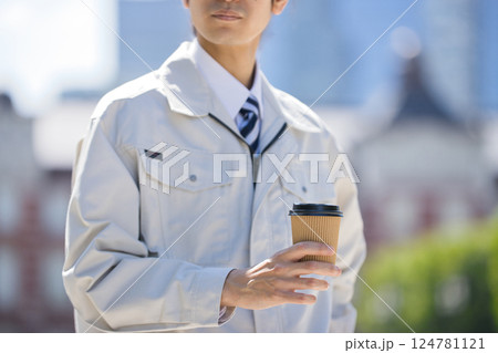 建設現場を背に腕組みをして立つ作業服の男性 124781121