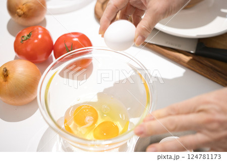 ボールに割った新鮮な卵を持つミドル女性の手 124781173