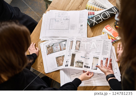 Collaborative workspace professionals reviewing architectural designs, diverse color samples, teamwork in action concept Collaborative workspace professionals reviewing architectural designs, diverse color samples, teamwork in action concept 124781235