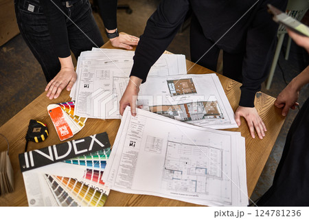 Architectural team reviewing construction blueprints, discussing project details at desk, collaboration in architecture concept Architectural team reviewing construction blueprints, discussing project details at desk, collaboration in architecture concept 124781236
