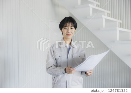 工場で図面を見る作業着姿の女性 工場で図面を見る作業着姿の女性 124781522