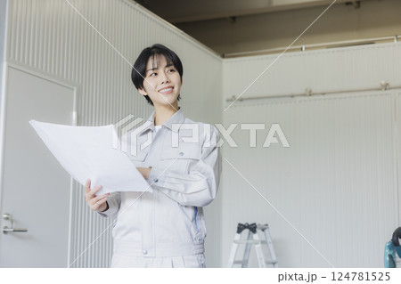 工場で図面を見る作業着姿の女性 工場で図面を見る作業着姿の女性 124781525