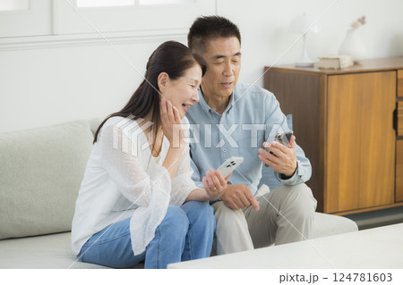 スマホを見る夫婦　 124781603