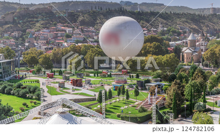 Aerial timelapse of Rike Park, a modern urban park in Tbilisi's Old Town with green trees and lawns. The Bridge of Peace in the background. Georgia Aerial timelapse of Rike Park, a modern urban park in Tbilisi's Old Town with green trees and lawns. The Bridge of Peace in the background. Georgia 124782106