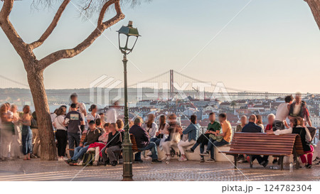 People watching city panorama with Bridge April 25th during sunset in Lisbon from Miradouro da Graca viewpoint timelapse, Portugal 124782304