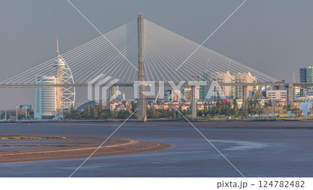 Vasco da Gama Bridge over river Tagus timelapse in Lisbon with park of Nations district modern architecture, Portugal Vasco da Gama Bridge over river Tagus timelapse in Lisbon with park of Nations district modern architecture, Portugal 124782482
