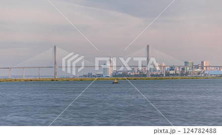 Vasco da Gama Bridge over river Tagus timelapse in Lisbon with park of Nations district modern architecture, Portugal 124782488