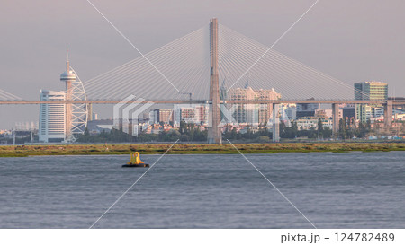 Vasco da Gama Bridge over river Tagus timelapse in Lisbon with park of Nations district modern architecture, Portugal 124782489