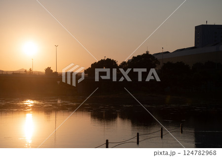 美しい夕日を映す公園の池の水面 124782968