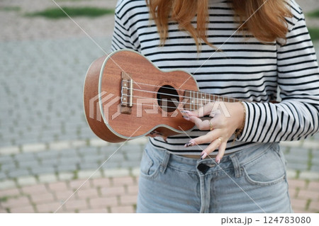 Artist Girl Plays Ukulele Musical Instrument Outside In Park 124783080