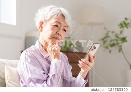 スマホを操作して困っているシニア女性 124783599
