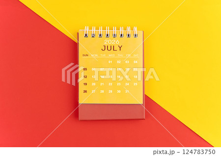 July 2026 desk calendar on red and yellow background. 124783750