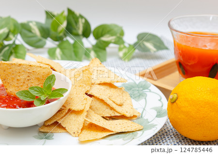 トウモロコシからできているトルティーヤチップスとサルサソースと野菜ジュース トウモロコシからできているトルティーヤチップスとサルサソースと野菜ジュース 124785446