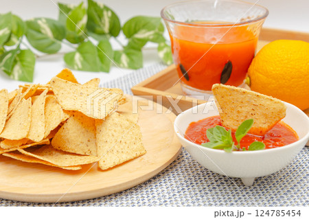 トウモロコシからできているトルティーヤチップスとサルサソースと野菜ジュース 124785454