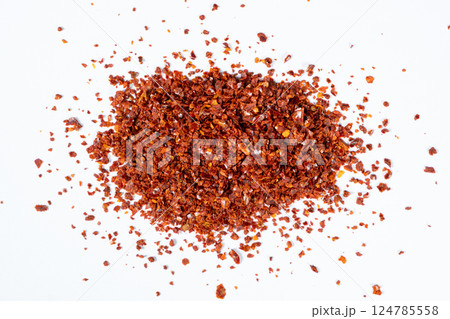 Hot chili peppers crushed and dried, natural seasoning on a white background isolate top view. Hot chili peppers crushed and dried, natural seasoning on a white background isolate top view. 124785558