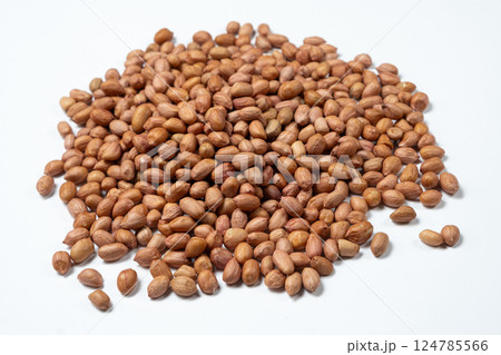 Raw peanut kernels in brown peel on white background close-up. Raw peanut kernels in brown peel on white background close-up. 124785566