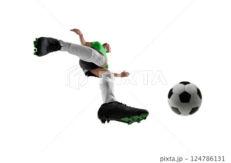 Low angle of powerful man, dressed sport uniform, soccer player turning mid-air for volley against white studio background. 124786131