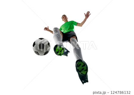 Low angle of focused man, dressed sport uniform, soccer player dribbling fast with intensity against white studio background. 124786132