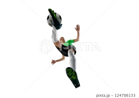 Low angle of energetic man, dressed sport uniform, soccer player sprinting with ball control against white studio background. 124786133