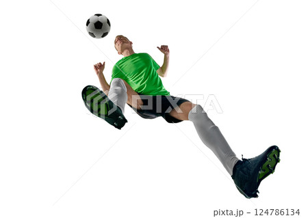 Low angle of male athlete, dressed sport uniform, soccer player jumping in motion to header against white studio background. 124786134