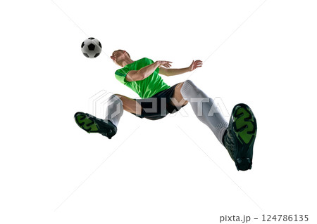 Low angle of male athlete, dressed sport uniform, soccer player jumping for header in motion against white studio background. 124786135
