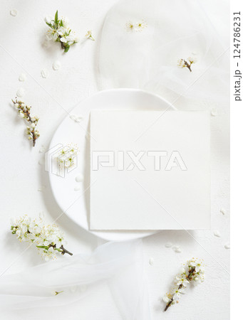 Blank card on plate near tulle and wild plums white flowers top view, romantic wedding mockup Blank card on plate near tulle and wild plums white flowers top view, romantic wedding mockup 124786231
