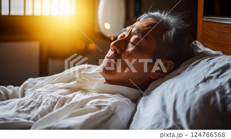 朝日に包まれて眠るシニア男性 124786568