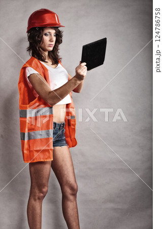 Sexy girl in safety helmet using tablet touchpad Sexy girl in safety helmet using tablet touchpad 124786758
