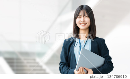 ノートパソコンを持つ笑顔の女性・ビジネスウーマン 124786910