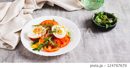 Light appetizer of tomatoes, boiled egg, cheese and arugula on a plate web banner Light appetizer of tomatoes, boiled egg, cheese and arugula on a plate web banner 124787670