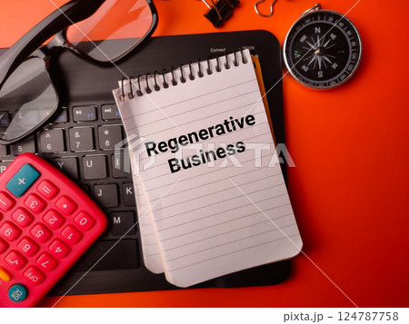 Top view black glasses,keyboard,calculator and notebook with the word Regenerative Business on a orange background. 124787758