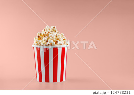 Classic red striped popcorn cardboard cup on Orange background Classic red striped popcorn cardboard cup on Orange background 124788231