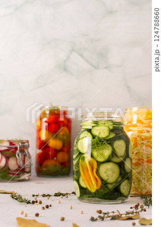 Fresh cucumbers fermenting in a jar with spices, creating a healthy probiotic-rich food, fresh fermenting vegetables like radishes, tomatoes, cabbage Fresh cucumbers fermenting in a jar with spices, creating a healthy probiotic-rich food, fresh fermenting vegetables like radishes, tomatoes, cabbage 124788660