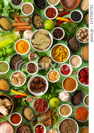 Fresh, fragrant spices and herbs arranged in an array of colors, sitting on a soft green backdrop, bringing flavor and zest to any kitchen Fresh, fragrant spices and herbs arranged in an array of colors, sitting on a soft green backdrop, bringing flavor and zest to any kitchen 124788791