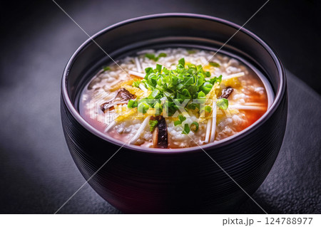Savory oatmeal made with chicken broth, topped with fried mushrooms and green onions, offering a satisfying and flavorful dish for any meal of the day 124788977