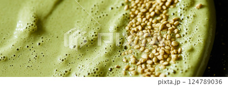 A matcha smoothie bowl, garnished with nuts and sesame seeds, sits in soft, natural light. Shadows stretch from the side of the window, adding depth and contrast to the healthy breakfast scene, banner 124789036