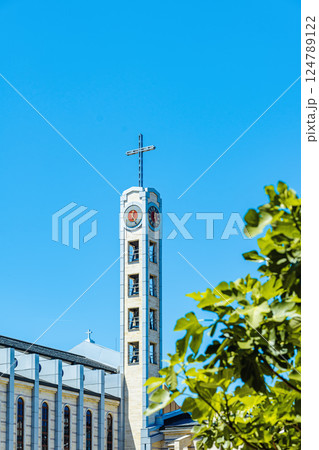 Clock tower of the Roman Catholic Cathedral of St Joseph in Sofia on blue sky background. Spiritual purpose in minimalist design and city integration concept 124789122