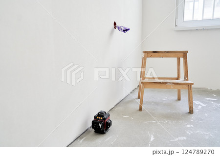 The electrical outlet is unfinished, the wires are rewound with purple electrical tape. A wooden stand next to the laser equipment. There is a place to copy. High quality photo The electrical outlet is unfinished, the wires are rewound with purple electrical tape. A wooden stand next to the laser equipment. There is a place to copy. High quality photo 124789270