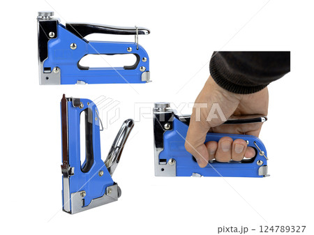 Metal construction stapler with blue body, in hand on white isolated background. There is a contour 124789327