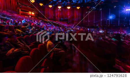 Spectators gather in the auditorium and watch the show in theatre timelapse. Large hall with red armchairs seats Spectators gather in the auditorium and watch the show in theatre timelapse. Large hall with red armchairs seats 124791628