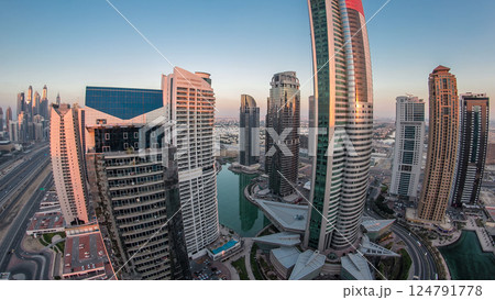 Buildings of Jumeirah Lakes Towers after sunset with traffic on the road day to night timelapse. Buildings of Jumeirah Lakes Towers after sunset with traffic on the road day to night timelapse. 124791778