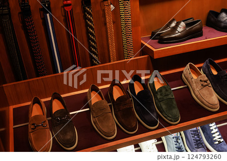 Elegant men's leather shoes on store shelves in mall. Shopping center. Men's clothing store. Elegant men's leather shoes on store shelves in mall. Shopping center. Men's clothing store. 124793260