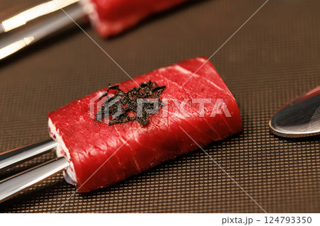Exquisite gourmet appetizer featuring delicate slices of raw beef wrapped around a creamy filling 124793350