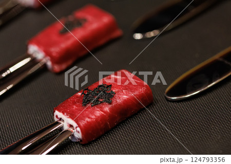 Exquisite gourmet appetizer featuring delicate slices of raw beef wrapped around a creamy filling Exquisite gourmet appetizer featuring delicate slices of raw beef wrapped around a creamy filling 124793356