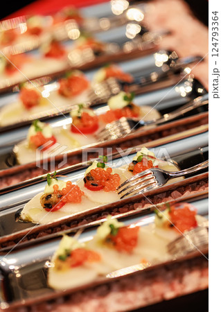 Elegant seafood appetizer featuring thinly sliced scallops, garnished with vibrant salmon roe Elegant seafood appetizer featuring thinly sliced scallops, garnished with vibrant salmon roe 124793364