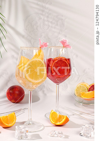Aperol Spritz cocktails with lemon and orange, ice cubes, rum and tequila. Summer party and holiday concept. Banner with alcoholic drinks and tropical fruits. Menu for a bar or cafe. Aperol Spritz cocktails with lemon and orange, ice cubes, rum and tequila. Summer party and holiday concept. Banner with alcoholic drinks and tropical fruits. Menu for a bar or cafe. 124794130