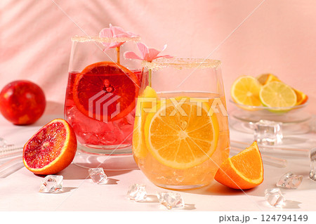 Royal cocktail of blood orange, lemon and lime, ice cubes, rum and tequila. Flyer with a glass of alcoholic drink and tropical fruits. Summer party concept. Menu for a bar or cafe. 124794149