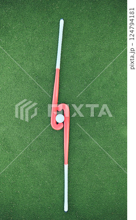 Hockey, sticks and ball on turf grass at a stadium for a sports match, exercise or training. Fitness, workout and sport equipment on outdoor field for championship game, practice or skill development 124794181